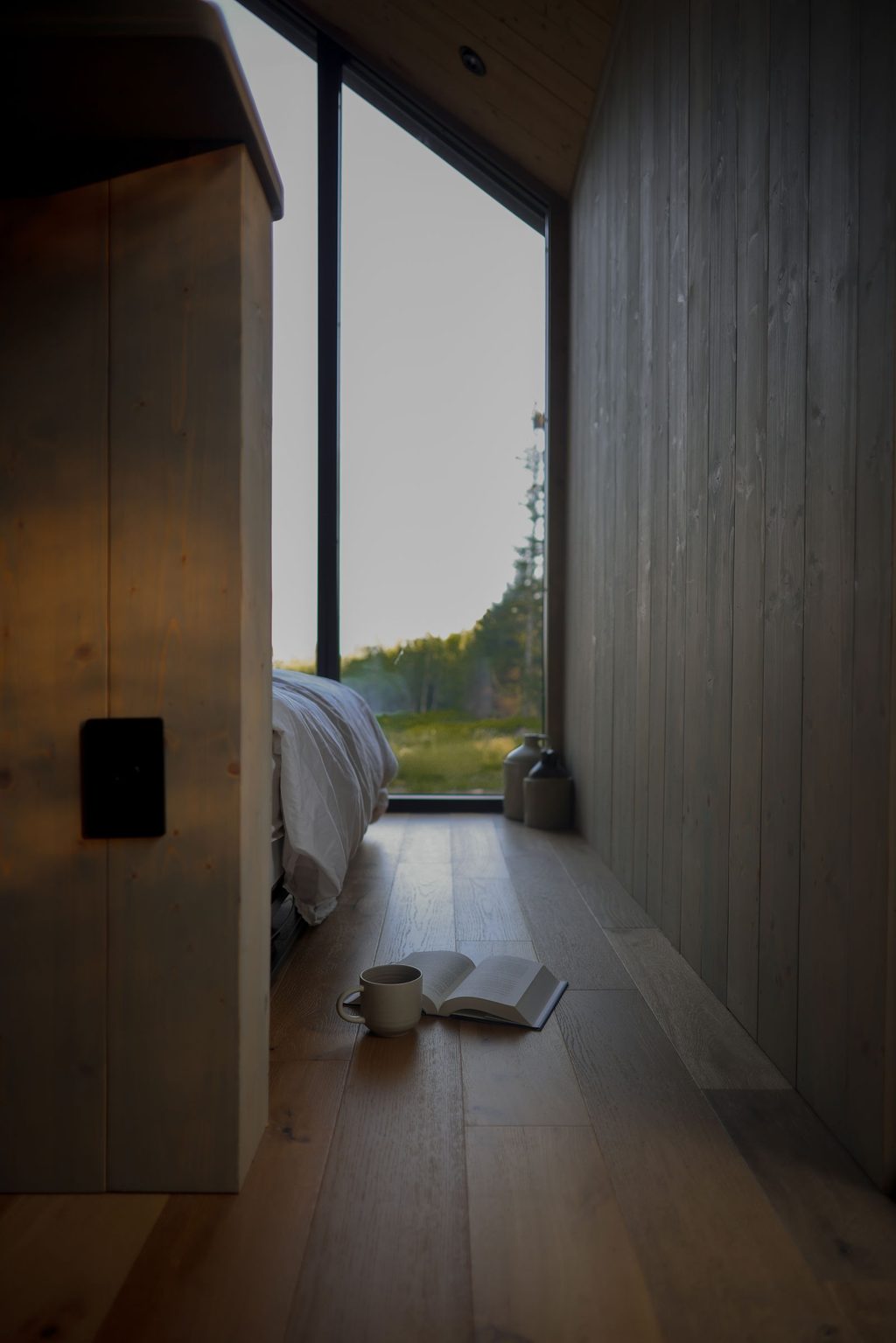 Timber hallway opening onto a window over the forest