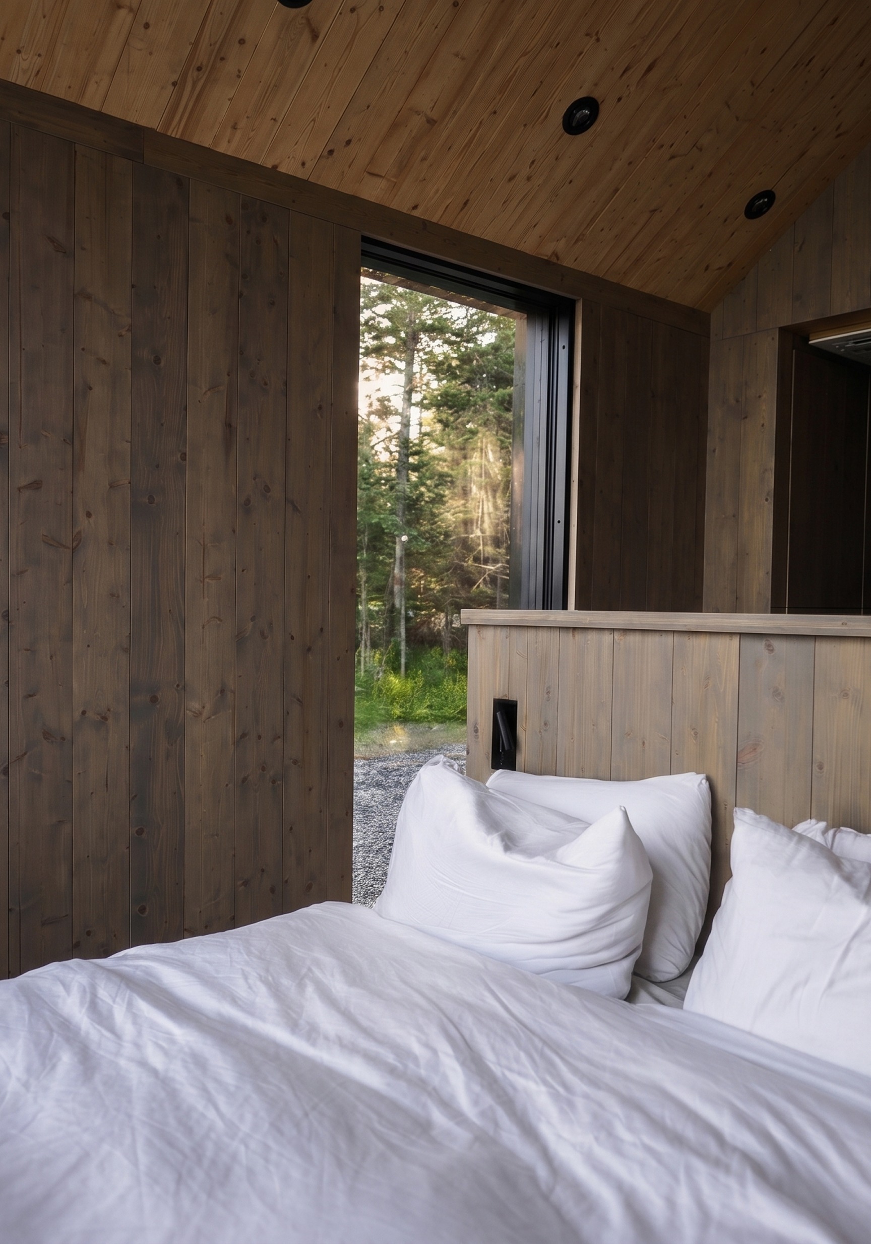 Timber hallway opening onto a window over the forest